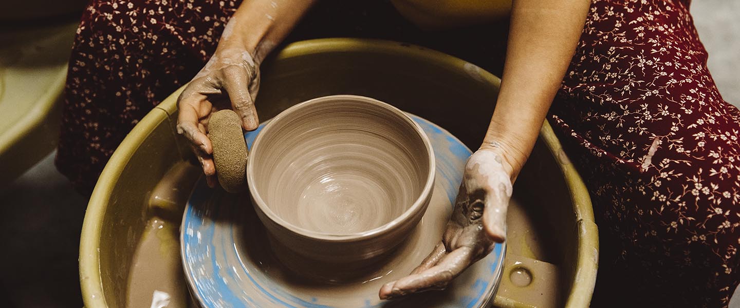 Art student turning pottery on a pottery wheel