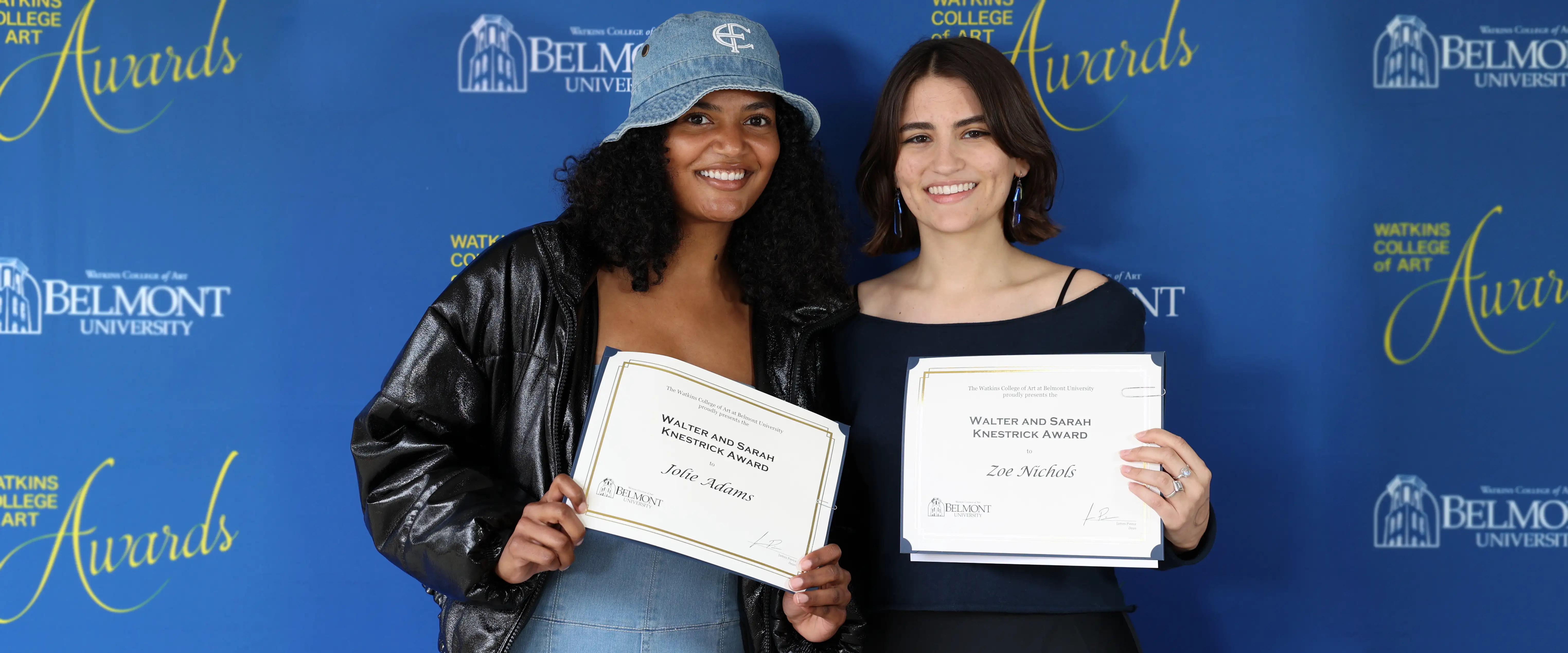 2 art student holding certificates at the watkins college of art awards ceremony