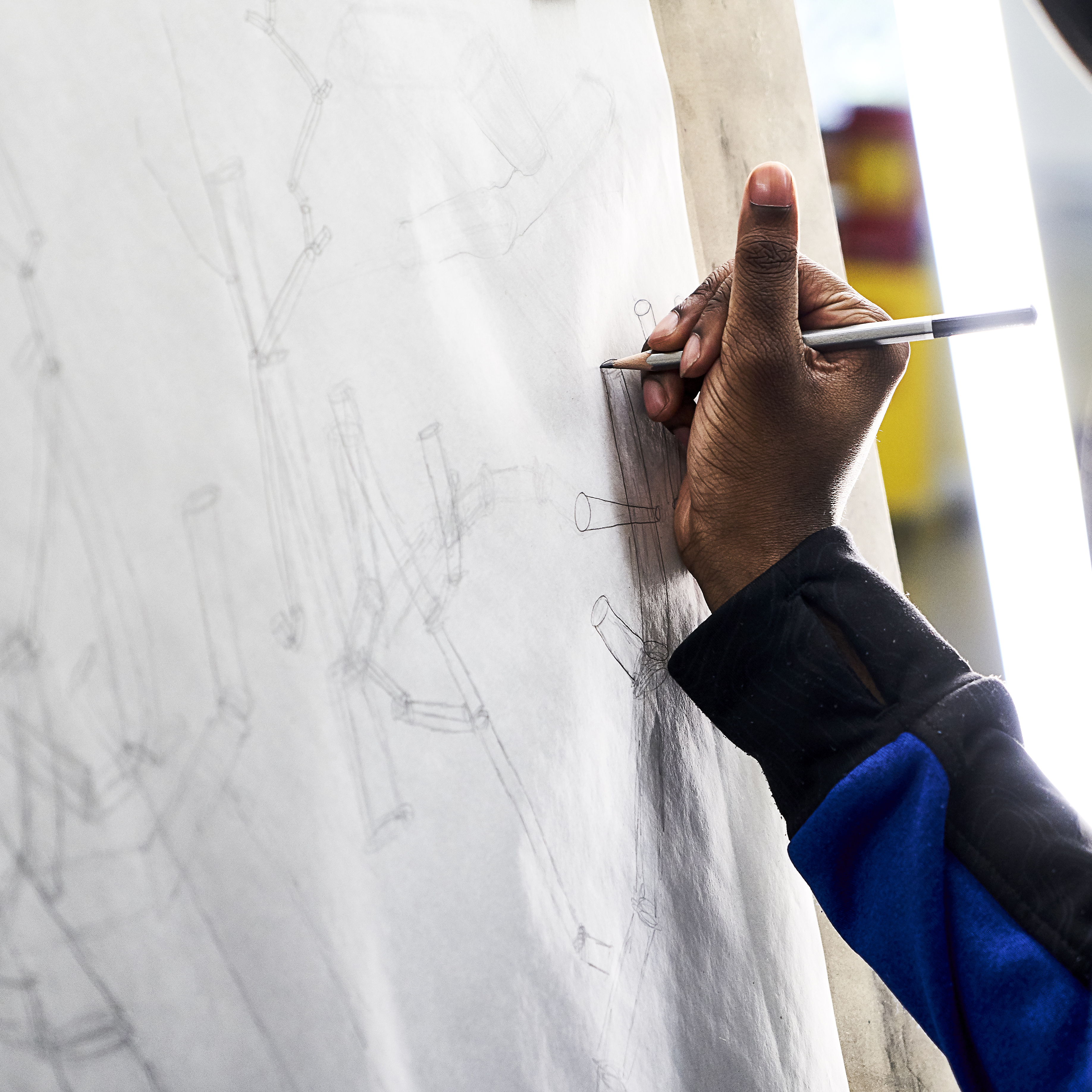 A student works in pencil on a sketch.